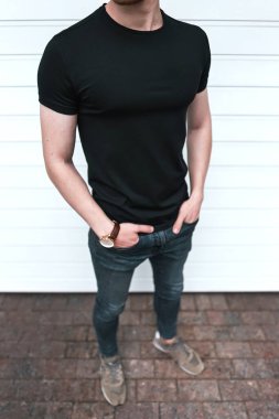 Siyah tişörtlü beyaz arka planda poz veren kişi