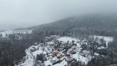 Kışın karla kaplı kır evleri ve ağaçlar
