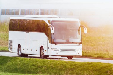 Sanayi binalarının yakınındaki kırsal yolda beyaz tur otobüsü