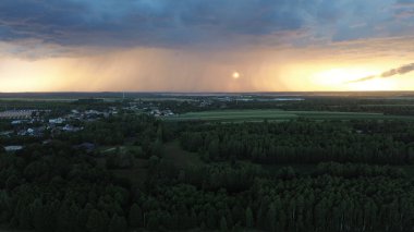 Kara fırtına bulutlarının yaklaştığı kırsal bölgede gün batımı