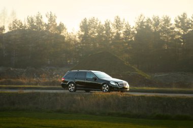 Huzurlu kırsal yolda giden bir mülk arabası.