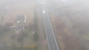 Hareket eden beyaz kamyonu olan puslu sabah yolu