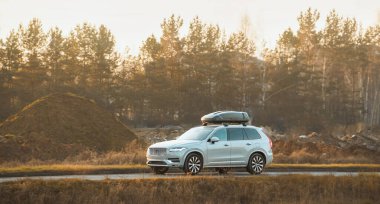 Çatı kargo kutusu olan araba otoyolda gidiyor.