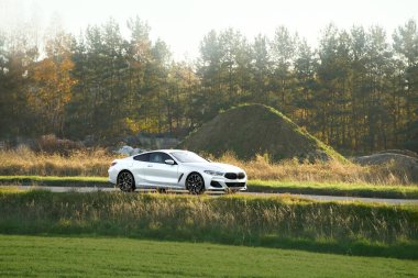 Kırsal yolda beyaz bir spor araba sürüyorum.