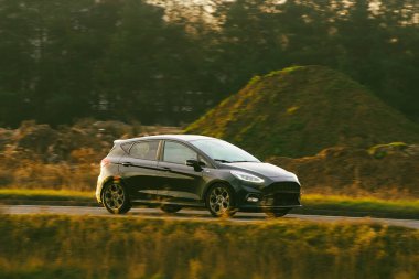 Küçük araba kırsalda hareket halinde.