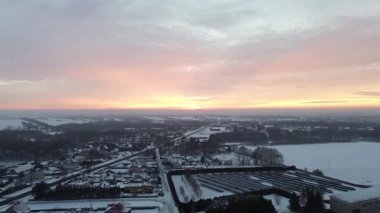 Çatılar ve sokaklar karla kaplı.