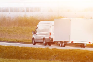 Parlak kırsal yolda çekici römorku var.