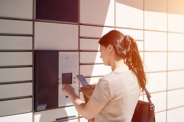 Dolabında kağıt paketi tutan kadın.