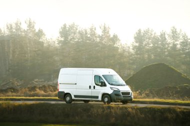 Teslimat aracı doğaya yakın asfalt yolda.