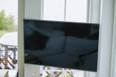 Televizyon ve okyanus manzaralı samimi bir iç mekan.