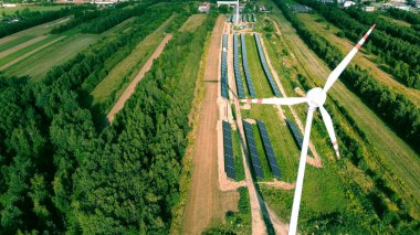 Rüzgar türbini ve güneş panelleri mavi gökyüzünün altında