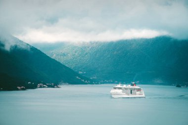 Köyün yakınındaki sakin sularda beyaz bir yolcu gemisi.