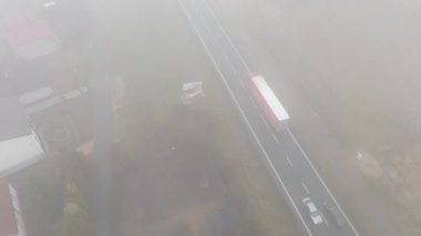 Hareket halindeki araçla yoğun siste kalan yerleşim yeri.