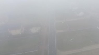 Hareket eden beyaz kamyonu olan puslu sabah yolu