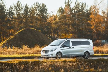 Sonbahar ağaçlarının yanında beyaz nakliye aracı