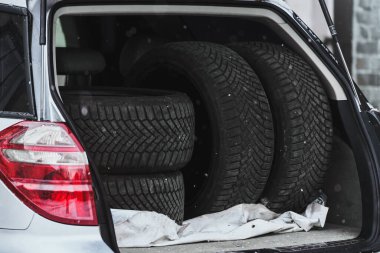 Arabanın bagajında yazlık lastikler var.