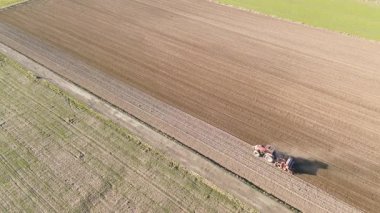 Tarıma elverişli arazide tarım traktörünün insansız hava aracı görüntüsü.