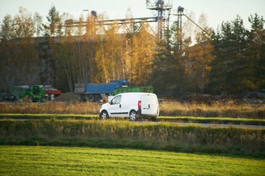 Kargo aracı ormanın yanından geçiyor.