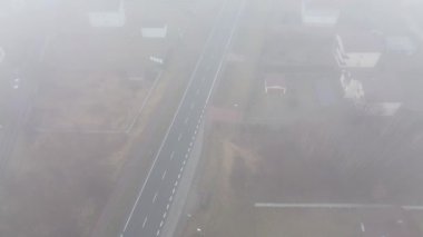 Hareket halindeki araçla yoğun siste kalan yerleşim yeri.