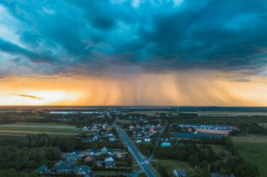 Altın saat ışığı kırsal kesimde kara bulutlara zıt düşüyor