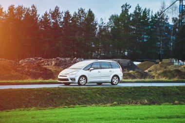 Yeşil manzaralı kırsal yol boyunca giden modern SUV