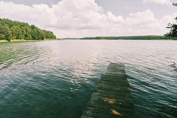 Sakin gölün kıyısındaki ahşap rıhtım.