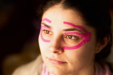 Pembe yüz bandı olan kadının yakın çekimi.