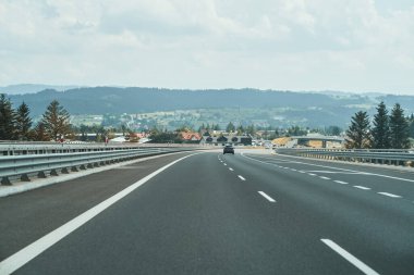 Araçlar bulutlu gökyüzünün altında otoyolda ilerliyor