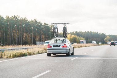 Otobanda bisikletle araba sürüyor.