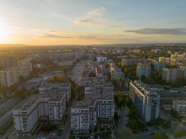 Güneşli bir akşamda şehrin apartman ve caddelerinin insansız hava aracı görüntüsü