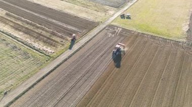 Güneş ışığında kuru tarım arazisi yetiştiren traktör.