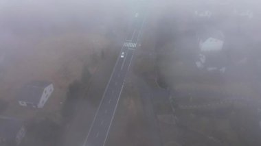 Banliyö yolları ve evleri üzerinde sonbahar sisi çöküyor