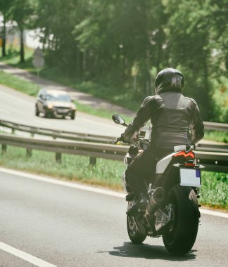Otoyolda kask takan motosikletli.