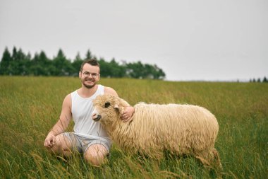İnsanlar ve koyunlar kırsalda birlikte oturuyorlar.