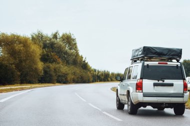 Otobanda çatıda uyku çadırı olan araba.
