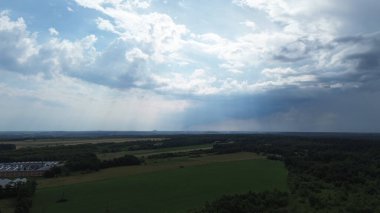 Geniş kırsal alanlar ve bulutlu gökyüzünün altındaki orman