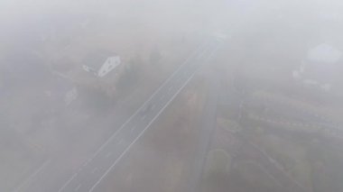 Hareket eden beyaz kamyonu olan puslu sabah yolu