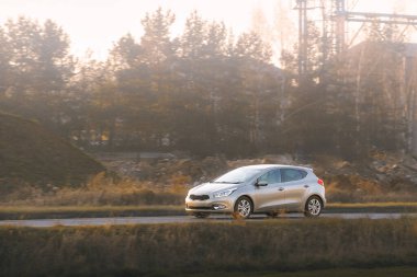 Kırsal yolda son sürat giden şık bir hatchback arabası.