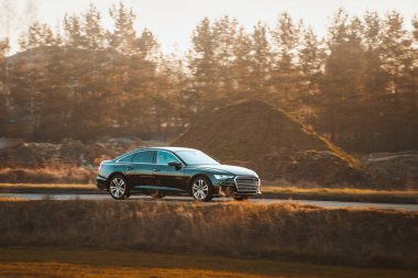 Akşam ışığında hızlı ve lüks bir araba.