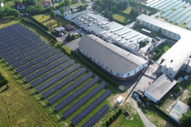 Güneş panellerine sahip fabrikanın hava görüntüsü yenilenebilir enerji için güneşin gücünü kullanıyor, sürdürülebilirliği ve çevre dostu uygulamaları destekliyor