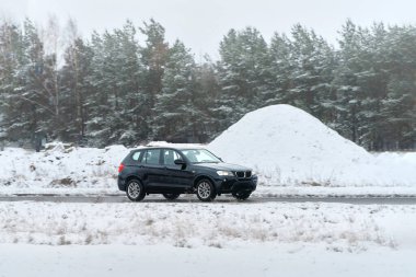 Gün batımında ormanda gezinen bir araç.