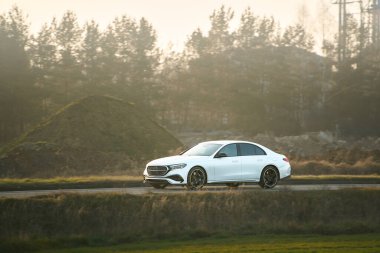 Akşam karanlığında kırsalda pahalı bir araba.