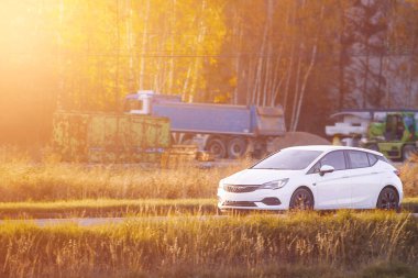 Kırsal alanda beyaz hibrit araba seyahat ediyor