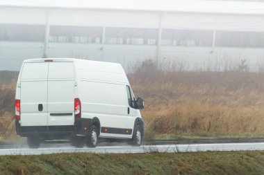 Beyaz minibüs köy yolunda hız yapıyor.