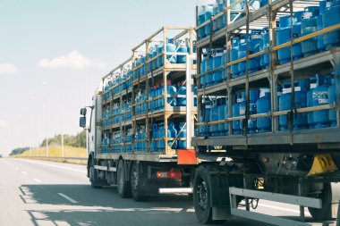 Karayolunda LPG benzin tankı taşıyan büyük bir kamyon.