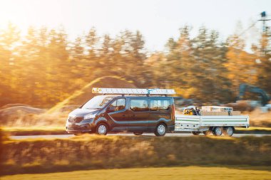 Merdiveni olan siyah bir minibüs ve dolu bir karavan.