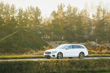 Modern beyaz araba doğal ortamda sürüyor.