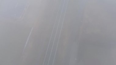 Banliyölerdeki puslu caddede gezinen arabanın insansız hava aracı görüntüleri.