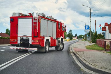 Kırmızı itfaiye aracı kasabanın yerleşim yerinden geçiyor.