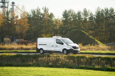 Kargo kamyonu çimlerin ve fabrikanın önünden geçiyor.